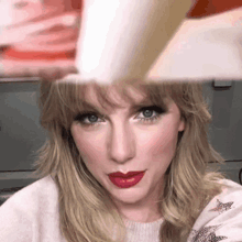 a close up of a woman 's face with red lipstick and a hat on her head .