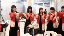 a group of young girls are stretching their arms in front of a sign that says ' a ' on it