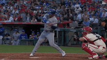 a baseball player wearing a blue jays uniform swings his bat