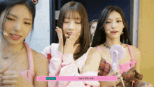 three girls are standing next to each other and one of them is holding a fan ..