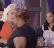 a group of women are sitting at a table with drinks .