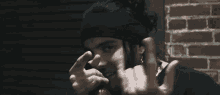 a man with a beard and a headband is giving the middle finger
