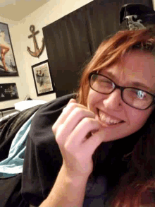a woman wearing glasses is smiling while laying on her back