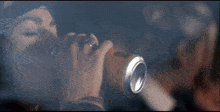 a woman in a bandana drinks from a can