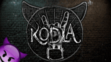a brick wall with a drawing of a cat with horns and the word koda on it