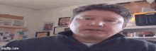 a man in a black jacket is looking at the camera with imgflip.com at the bottom right