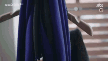 a blue scarf is hanging on a hanger in a room .