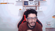 a man sitting in front of a sign that says twitch
