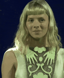a woman with blonde hair is wearing a white dress with the word mom on the front