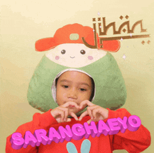 a little girl wearing a hat with the name saranghaeyo on her shirt
