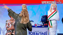a woman is standing in front of a caffe borbone sign