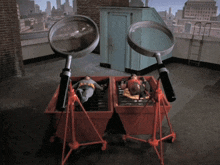 a couple of magnifying glasses are sitting on top of a red bin