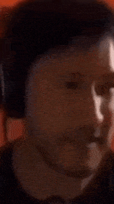 a close up of a person wearing headphones and making a funny face .