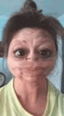 a woman in a yellow shirt is making a funny face with her eyes closed .