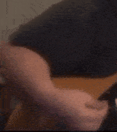 a close up of a person 's arm wearing a black shirt and a black belt .