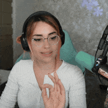 a woman wearing glasses and headphones is giving the ok sign