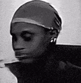 a black and white photo of a person 's face with a wig on their head .
