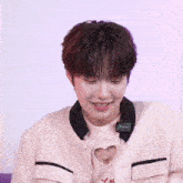 a young boy wearing a pink sweater that says love high on it