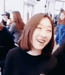a woman with short hair is smiling in a crowd