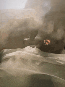 a person laying on a bed with smoke coming out of their nose