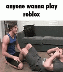 two men are doing exercises on the floor in a living room while a couch is in the background .