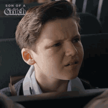 a young boy is making a funny face with the words son of a grifch behind him