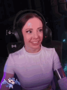 a woman wearing headphones and a white shirt is sitting in a chair .