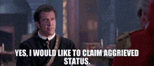 a man in a suit and tie says " yes , i would like to claim aggreeved status "