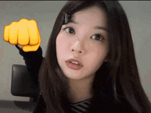 a girl with a yellow fist pointing at something