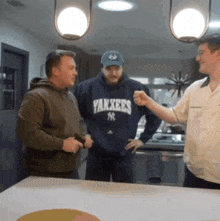 a man wearing a yankees sweatshirt has his fist up
