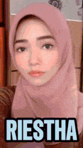 a woman wearing a pink hijab with the name riestha written on the bottom