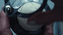 a person is holding a magnifying glass over a ball