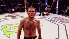 a man in a boxing ring with a monster energy logo on the ground