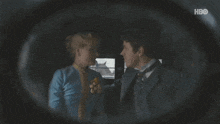 a man and a woman are looking at each other through a magnifying glass with hbo in the corner