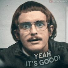 a man with glasses and a mustache is wearing a shirt that says " yeah it 's good "