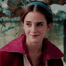 a close up of a woman wearing a headband and a red jacket