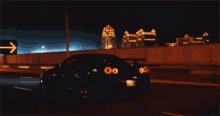 a car is driving down a highway at night with a sign in the background that says ' ksa '