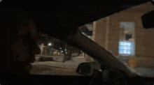 a man is driving a car and smoking a cigarette while looking out the window .