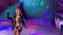 a woman in a yellow and black outfit is walking on a stage