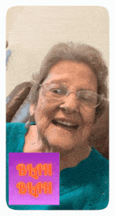an elderly woman sitting in a chair with a blah blah sticker behind her