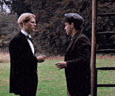 two men in suits and hats are standing in a field