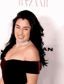 a woman wearing a choker and a black dress is smiling .