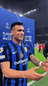 a soccer player wearing a betsson sport jersey shakes hands with someone