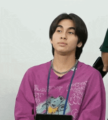 a young man wearing a purple shirt that says " nobody " on it