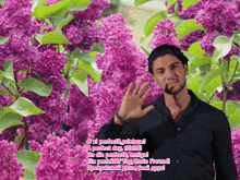 a man in a black shirt stands in front of purple flowers with the words a perfect day friend