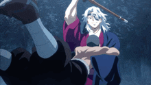 a man in a kimono is holding another man in his arms while holding a stick