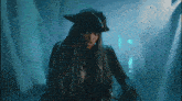 a woman with long dreadlocks and a pirate hat stands in a dark room