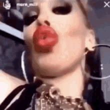 a close up of a woman 's face with red lips and earrings .