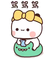 a cartoon character with a yellow bow on her head is sitting on a green frog holding a cell phone .
