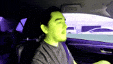 a man in a car with a green face